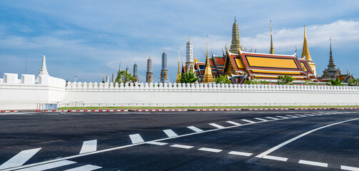 Grand Palace, also known as Wat Phra Kaew, as seen from the bustling streets of vibrant Bangkok, Thailand on a sunny day.