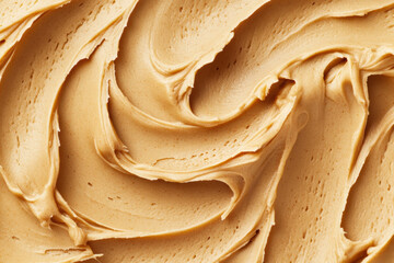 An image of smooth, creamy peanut butter spread across a surface with visible swirls and texture.