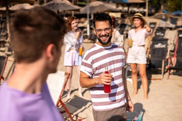 Two male friends met at the beach to hang out. Drinking alcohol and fooling around.