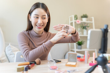 asian female beauty social media influencer livestream marketing cosmetics a make up tutorial via smartphone.