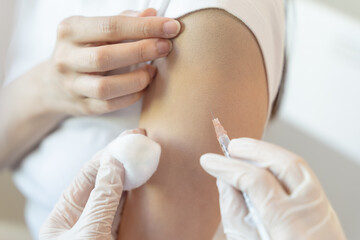 People getting a vaccination to prevent pandemic concept. Woman in medical face mask  receiving a dose of immunization coronavirus vaccine from a nurse at the medical center hospital