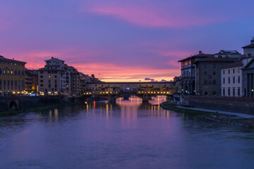 Obraz premium View of the iconic Ponte Vecchio over the Arno River at dusk in Florence, Italy.
