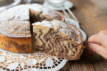 Marble cake with zebra pattern on wooden table