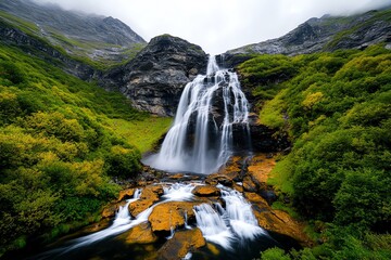 Fototapeta premium A waterfall cascading down a cliff, water rushing and mist rising in the air, flowing continuously