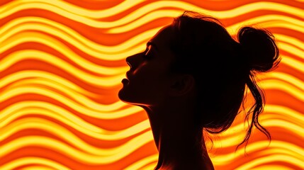 Woman's silhouette against a backdrop of wavy orange neon lights 