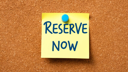 Reserve now word written on a note sticky on corkboard