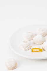 White mochi with yellow filling on white background