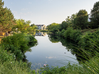 Obraz premium Tranquil Pond in Suburban Neighborhood with reflections from trees and houses in Ashburn, Virginia