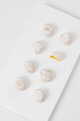 White mochi with yellow filling on white background