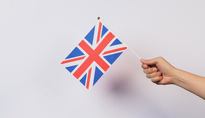 Hand is holding Union Flag or Union Jack on white background.