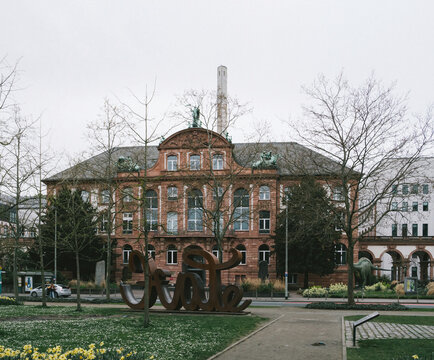 Frankfurt, Germany - Mar 31, 2024: Street view of the Senckenberg Nature Museum in Frankfurt during early spring, with budding trees and a mix of historical and modern architecture in the background.