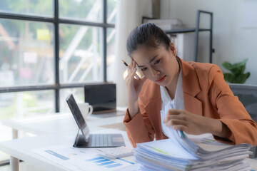 Obraz premium Sad Tired Asian woman Overworked On Computer.Unhappy Frustrated Business Woman, Business Finance Deadline.Sad Tired Businesswoman In Office.Annoyed Overwhelmed Exhausted Stressed