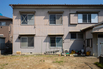 二階建てアパート、老朽化した下宿屋、窓の割れたアパート