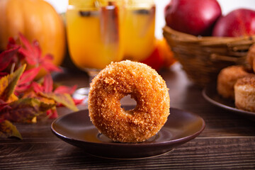 Sweet homemade apple cider donuts with cinnamon sugar on the wooden table. Autumn food.