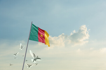 Cameroon flag waving with flying doves in beautiful sky. Cameroon flag for Republic Day and Independence Day.