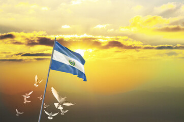 El Salvador flag waving with flying doves against sunset or sunrise. El Salvador flag for Republic Day and Independence Day.