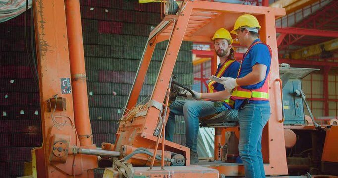 Construction workers engineers in yellow hard hats and safety vests are discussing operate a construction lift machinery within an industrial environment, focus on occupational safety and teamwork
