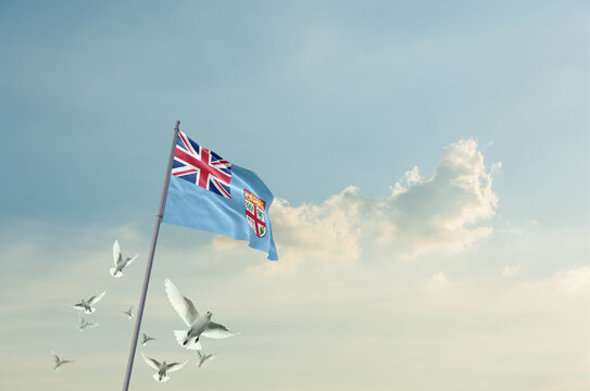 Fiji flag waving with flying doves in beautiful sky. Fiji flag for Republic Day and Independence Day.