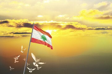 Lebanon flag waving with flying doves against sunset or sunrise. Lebanon flag for Republic Day and Independence Day.