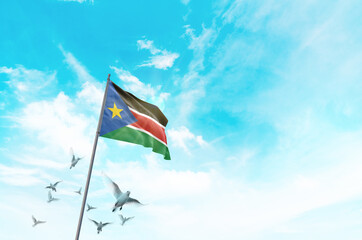 South Sudan flag waving with flying doves in beautiful sky. South Sudan flag for Republic Day and Independence Day.