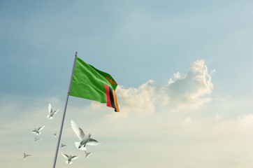 Zambia flag waving with flying doves in beautiful sky. Zambia flag for Republic Day and Independence Day.