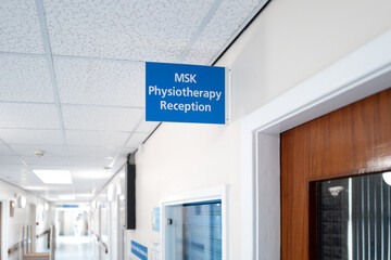 NHS hospital physiotherapy reception sign located within an outpatients department in a busy...