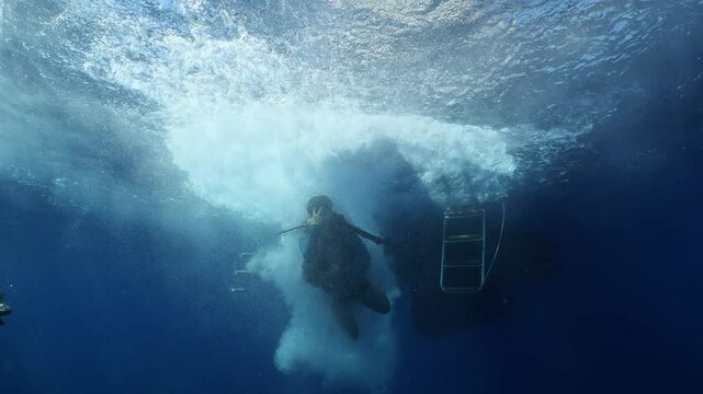boat underwater scuba diver jumps into water ocean scenery