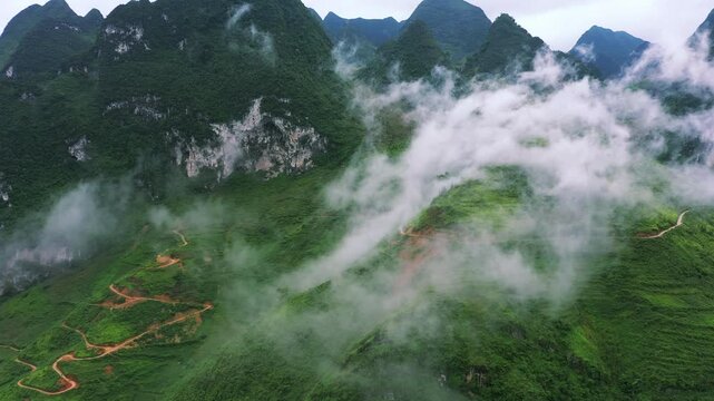 Drone of mountains, river and highway in nature for travel, adventure or holiday with eco tourism background. Aerial view of green landscape, clouds or road infrastructure in Vietnam, Ma Pi Leng Pass