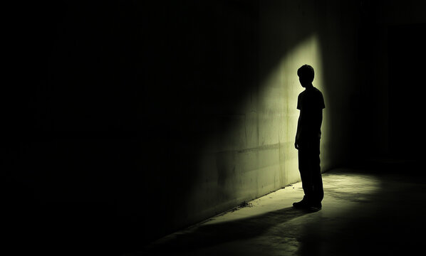 A haunting image of a man&rsquo;s silhouette alone in the dark, evoking deep feelings of fear, loneliness, emotional discomfort, and vulnerability in an eerie atmosphere.