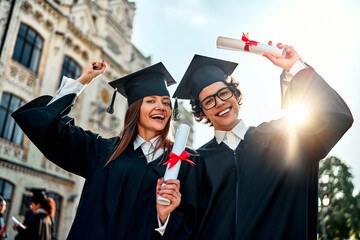 Happy graduates celebrate graduation. Smiling graduate friends rejoice at the successful completion...
