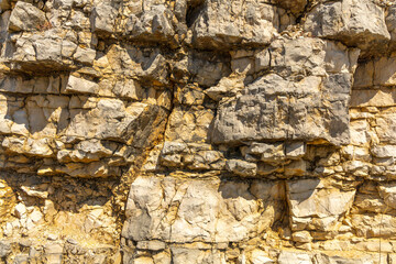 Detail of natural stone layered granite wall. Gray and yellow tones. Ourém Portugal