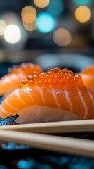 Salmon nigiri sushi topped with vibrant orange roe on plate with chopsticks