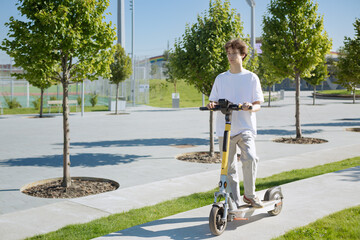 Young  man  renting scooter in city public eco transport mobile application, traffic alone outdoor...