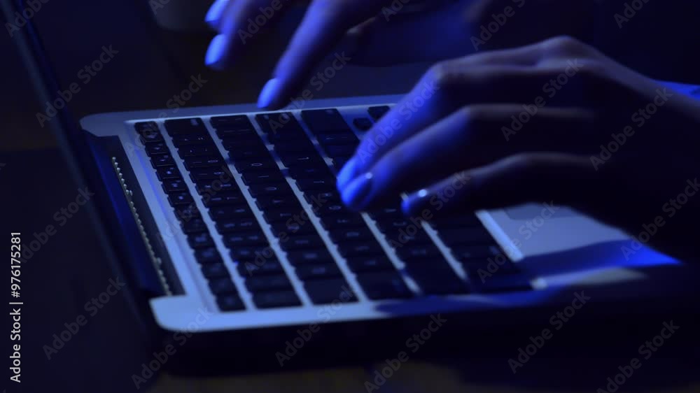 Poster Fingers swiftly type on a laptop keyboard, illuminated by a subtle blue glow, capturing the quiet intensity of late-night focus.