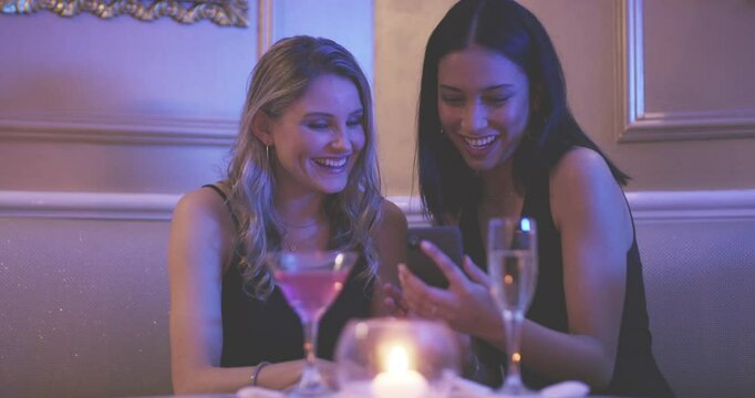Phone, night club and women friends at a party with social media, search or texting, bond or having fun. Clubbing, happy and people in a booth with smartphone, app or conversation, meme or blog post