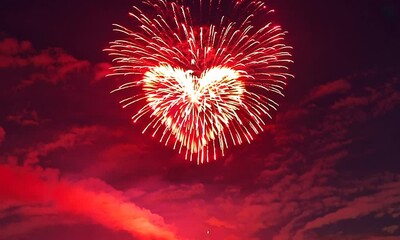 Romantic couple admiring heart shaped fireworks display