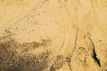 Gelber Sandboden mit Muster bei Sonne am Nachmittag im Sommer