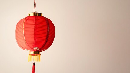 Obraz premium A vibrant red lantern hanging against a light solid color background, symbolizing good fortune for the Chinese New Year