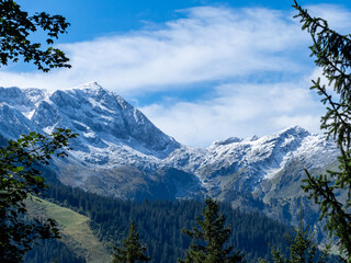 le grand mont en beaufortain, secteur arêches. neige saupoudrée sur les montagnes et encadré d'épicéas et d'arbres.