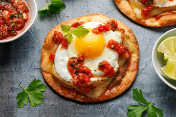 Huevos Rancheros tostadas with fried egg, tomato salsa, bean paste and cheese. Mexican food
