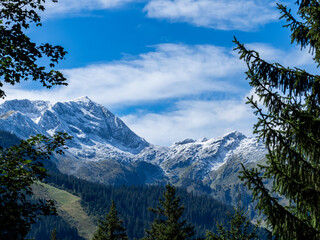 le grand mont en beaufortain, secteur arêches. neige saupoudrée sur les montagnes et encadré d'épicéas et d'arbres.