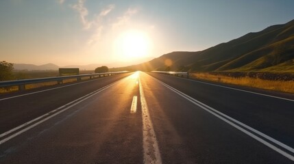 Morning view of a black asphalt road with clear white dividing lines and early sunlight