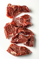Obraz premium Freshly cut and arranged raw meat on a clean white surface