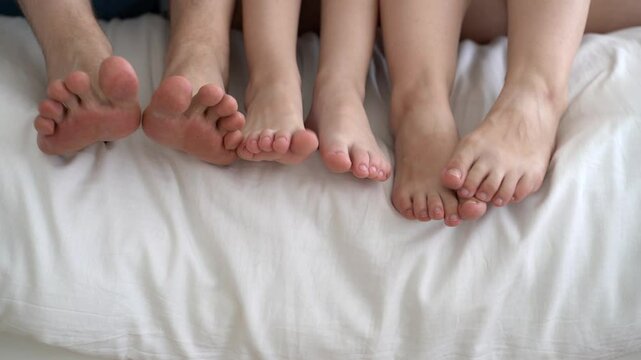 Three barefoot people, mother, father and daughter resting on the sofa, foot closeup, corns and calluses on feet, dry skin on legs, cracked heels, body care concept