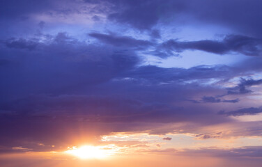 A stunning sunset casts warm colors across a mesmerizing canvas of dynamic clouds in the evening sky