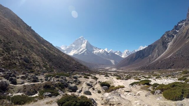 Panoramic view of mountain valley and footpath in Himalayas with Ama Dablam mountain in front and Mounts Cholatse and Tobuche in the right in sunny morning on Lukla - Everest base camp trekking route.
