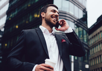 Happy man in formal wear calling to business partner for communicate during work break in financial...
