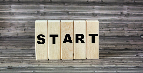 Wooden cubes with the word START on a wooden background