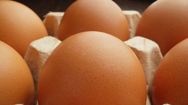 Brown eggs. Protein for diet. Farm fresh eggs nestled in rustic paper tray. Chicken eggs packed in cardboard box. Macro dolly out shot. Close-up in 4K, UHD