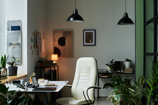 Home office boasting modern decor and ample natural light, featuring minimalist furniture and various plants enhancing productivity and comfort amidst a serene environment